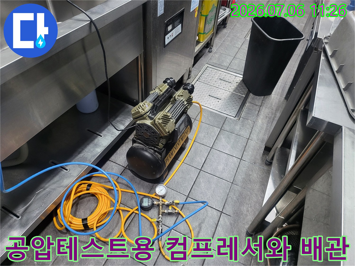 주방 바닥에 설치된 공압 테스트 장비와 연결된 호스