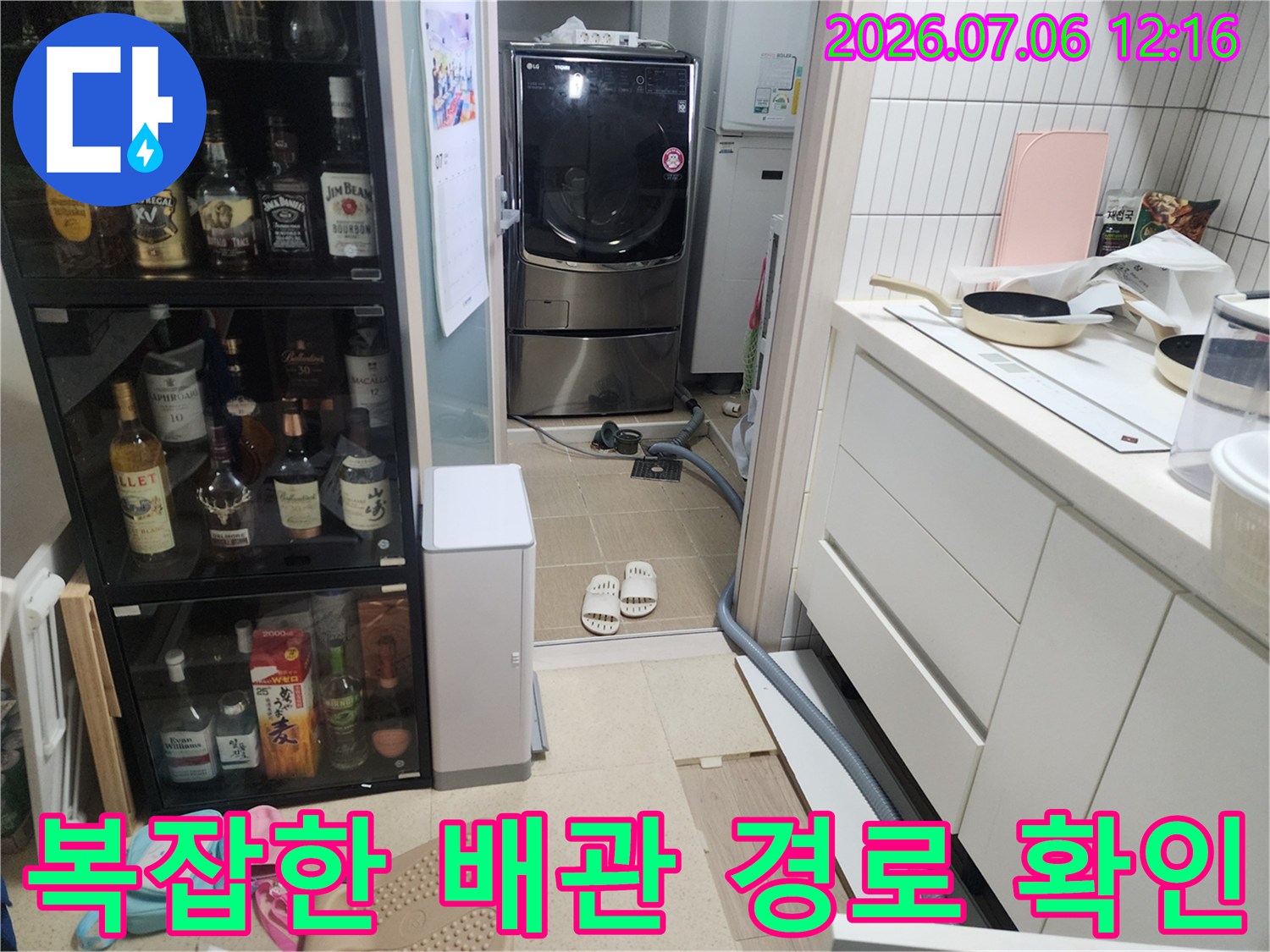 주방 공간의 복합적인 배관 시스템을 점검하며 누수 지점을 찾는 모습