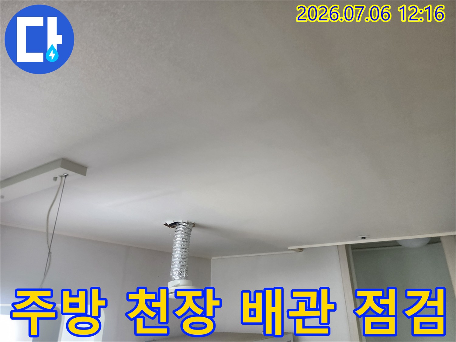 주방 천장의 은색 덕트와 상부 배관을 점검하는 모습