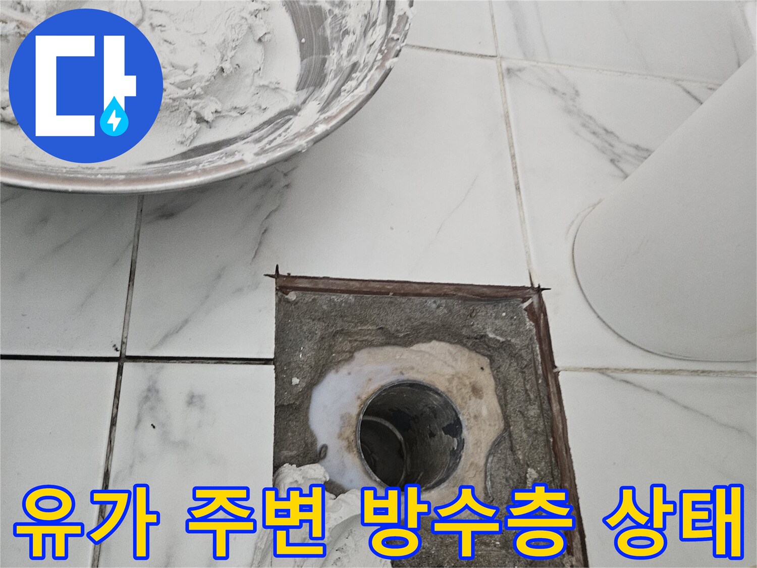 배수구 근처의 파손된 방수재와 노출된 배관을 보여줍니다.