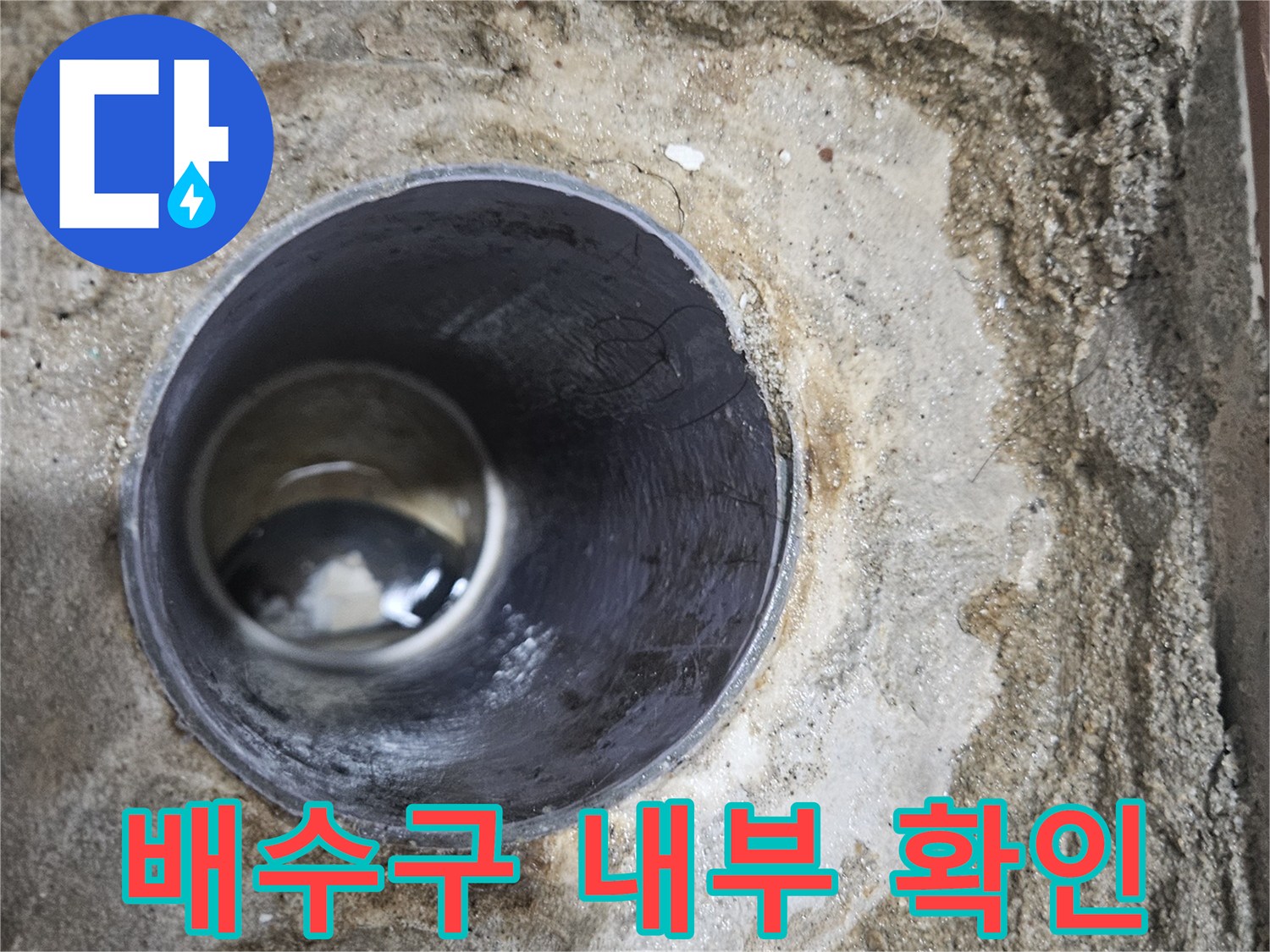 화장실 배수구 주변의 파손된 방수층과 노출된 배관 상태를 보여주는 사진입니다.