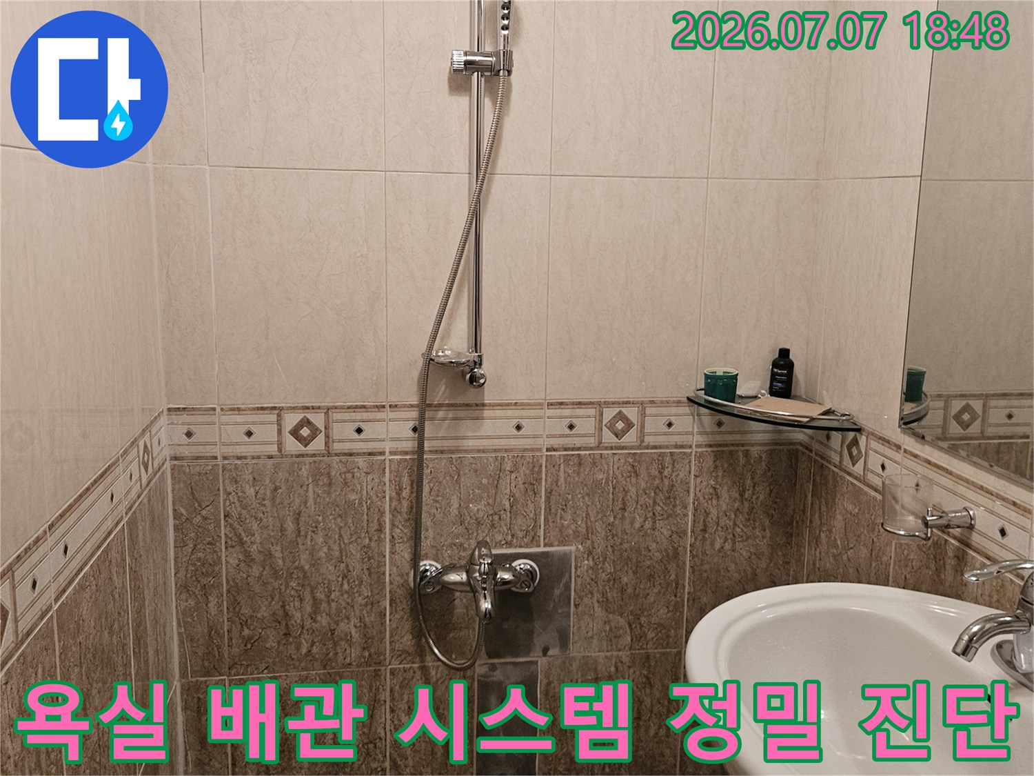 세면대 옆벽으로 이어진 욕실 내부 배관의 상태를 전문적으로 점검하는 모습