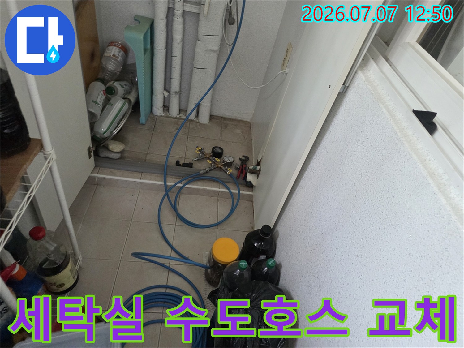 다용도실 안쪽의 노후된 고압호스와 연결 부위의 수리 작업 장면