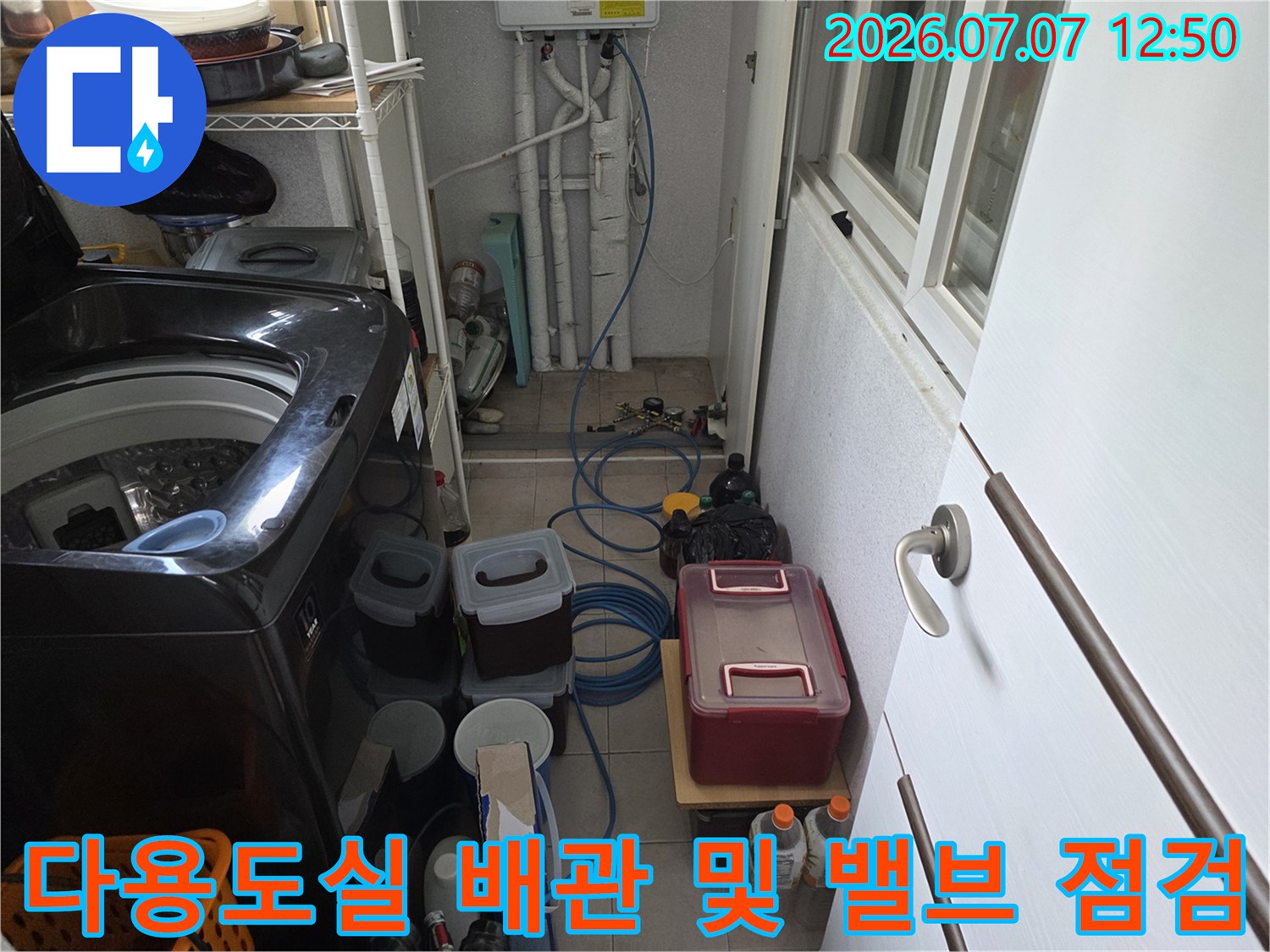 세탁기 옆에 위치한 수도 배관과 노출된 연결부의 점검 모습