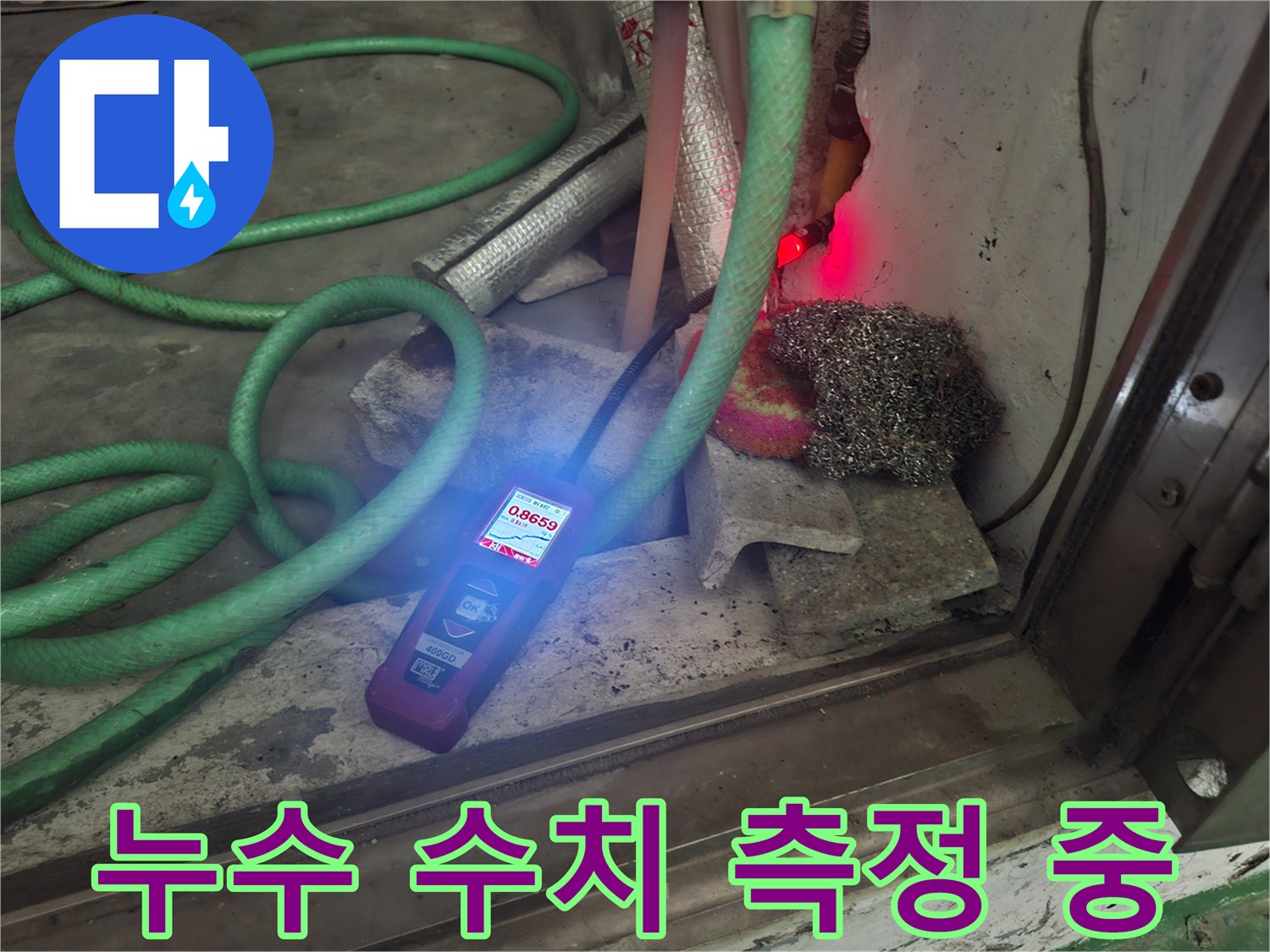 디지털 탐지기 화면의 숫자를 확인하며 누수 범위를 좁혀가는 장면입니다.