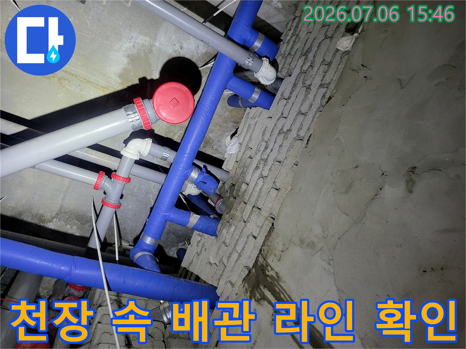천장 내부의 복잡한 파란색 및 회색 배관들이 얽힌 구간을 정밀하게 점검하는 모습