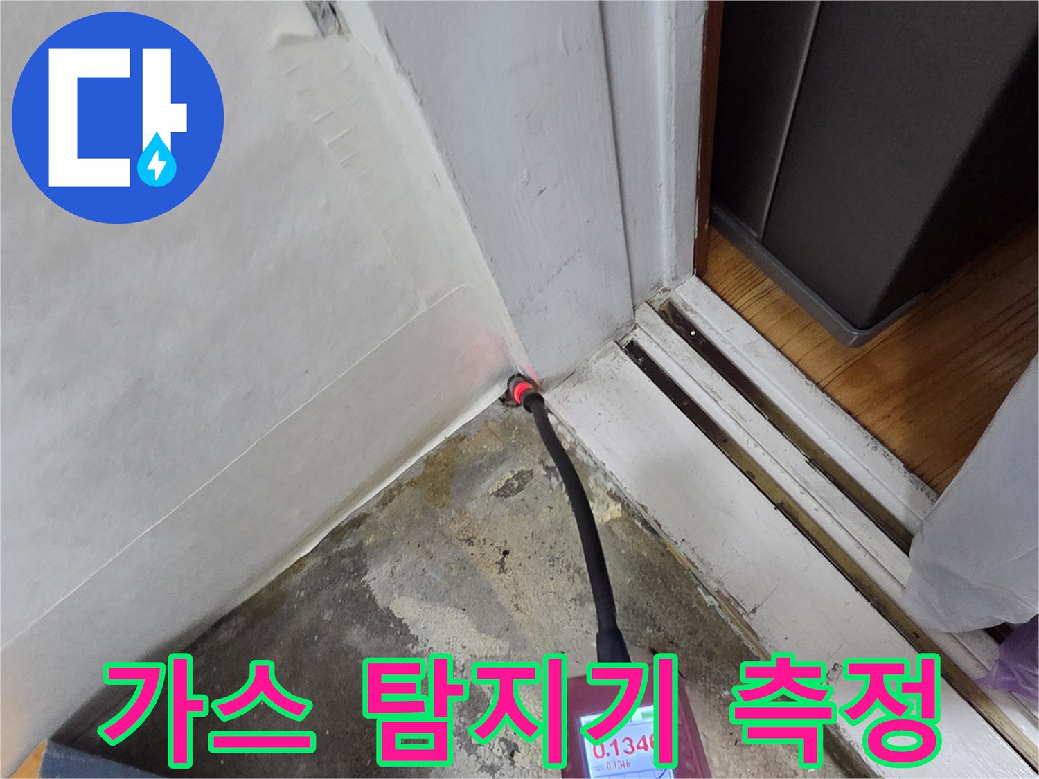 배관 누수를 찾기 위해 가스 탐지기를 벽면 하단에 대고 수치를 확인하는 모습입니다.