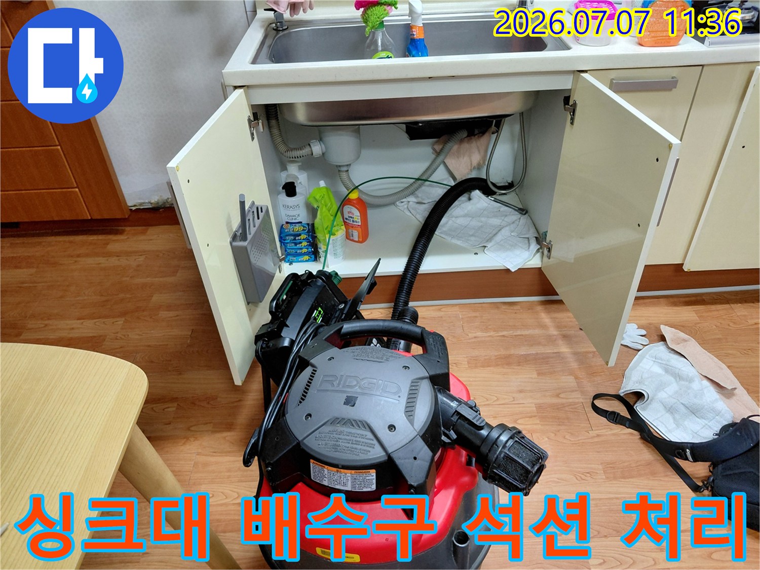배수 불량으로 고민하시는 고객님을 위해 싱크대 하부 배관을 석션 장비로 청소하는 장면