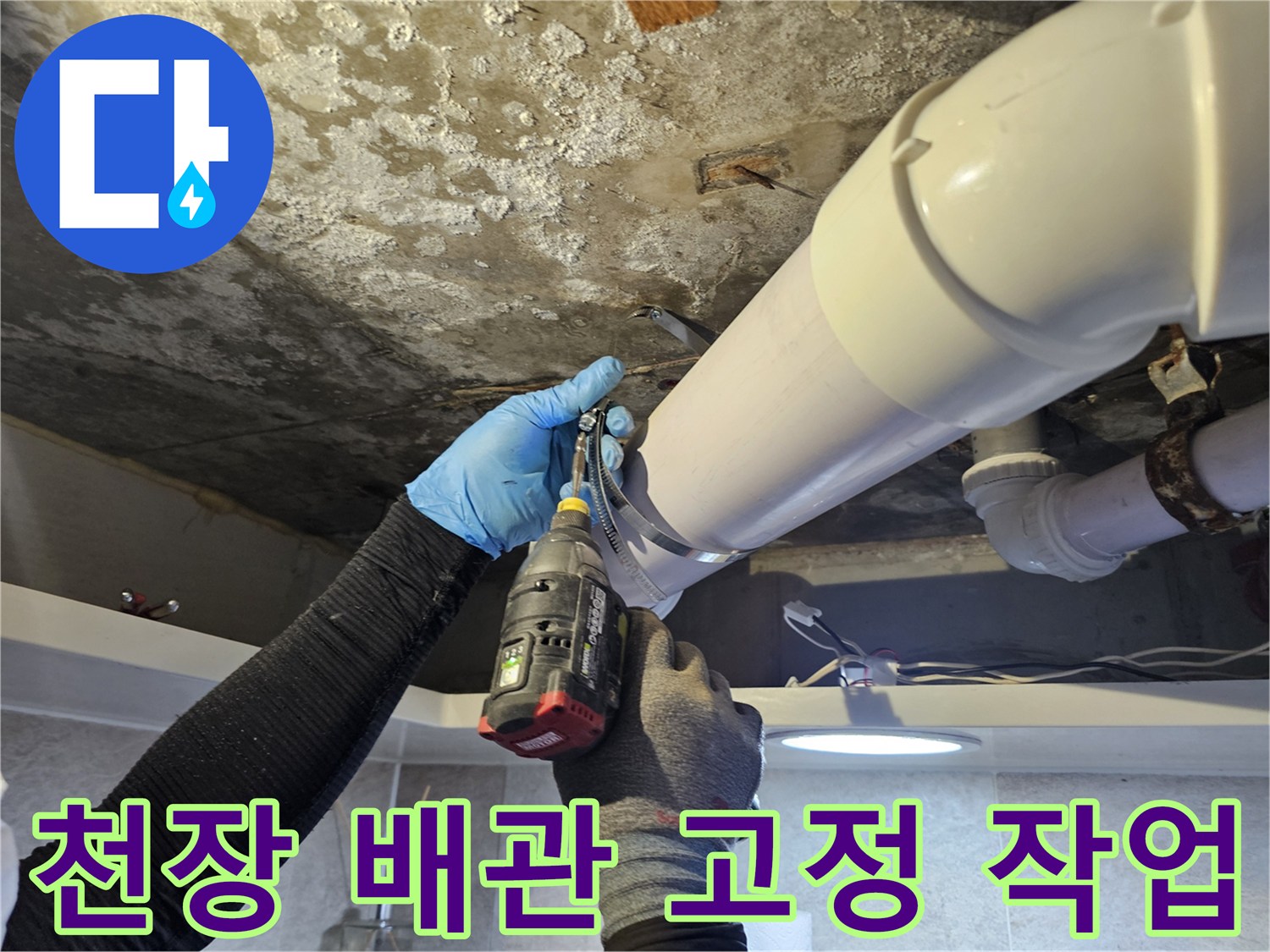 배관 연결 부위에 전동 드릴로 나사를 박아 고정하는 장면