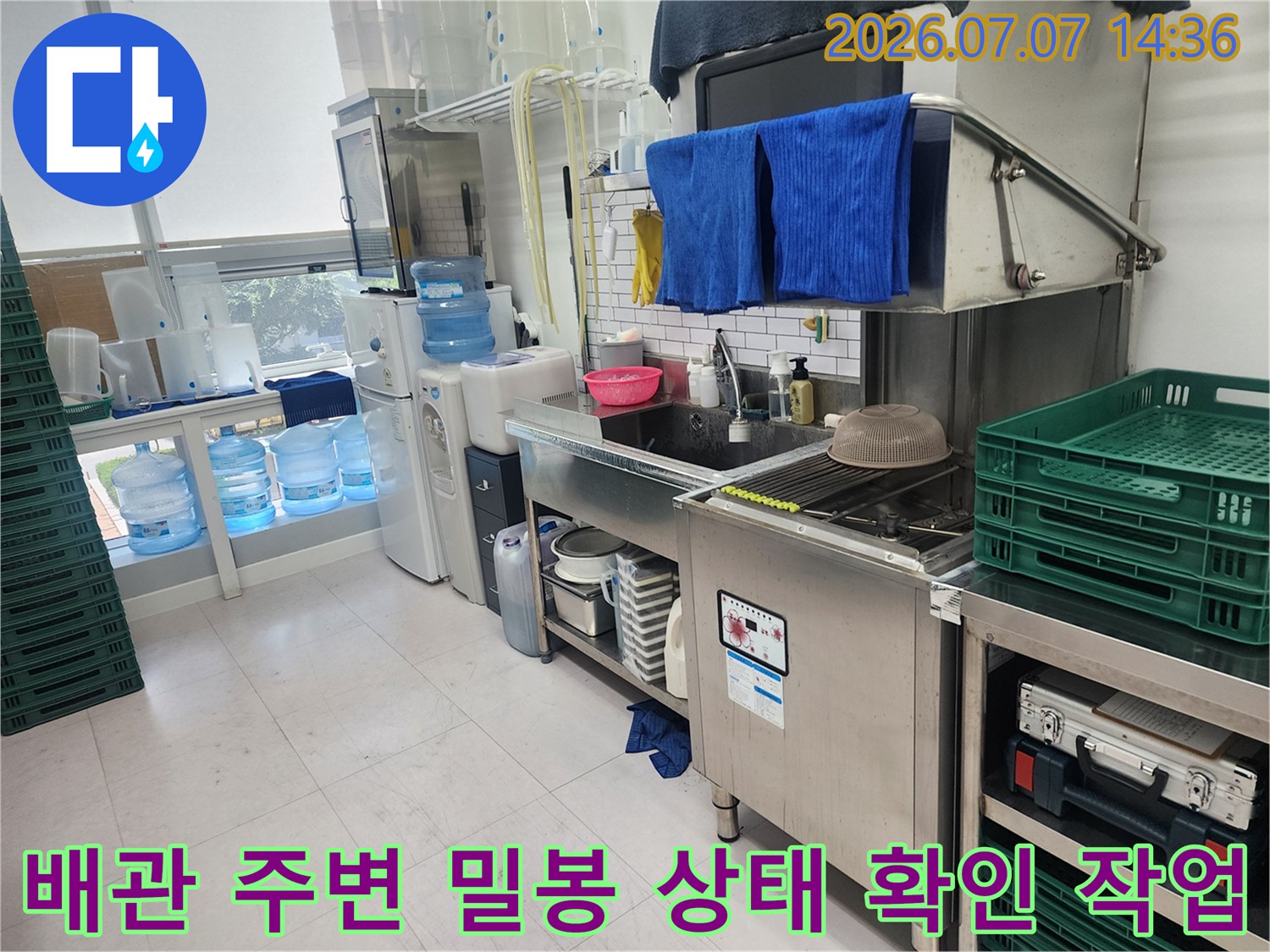 대형 물통과 수전 배관이 연결된 화장실 내측 모습