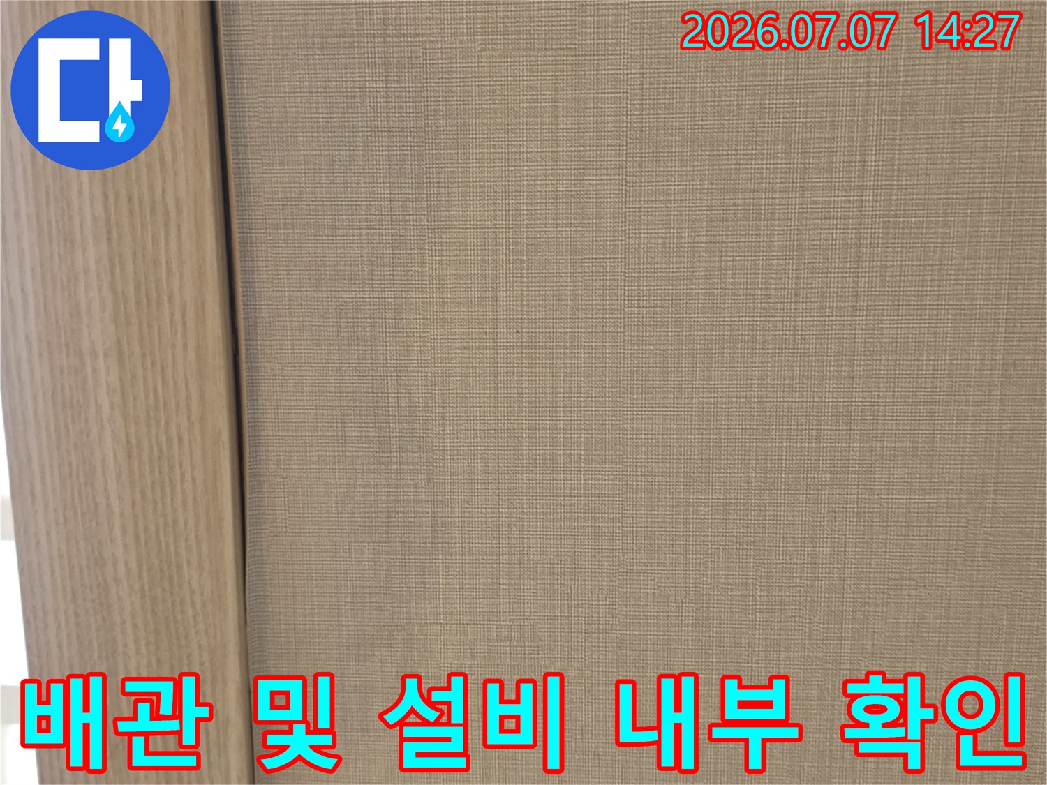 절개된 천장 마감재와 그 아래로 지나가는 배관망