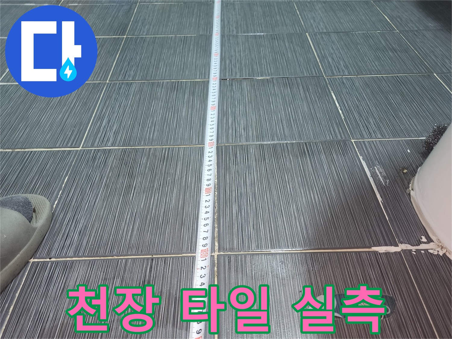 길이 측정을 진행하는-화장실 천장 타일 벽면