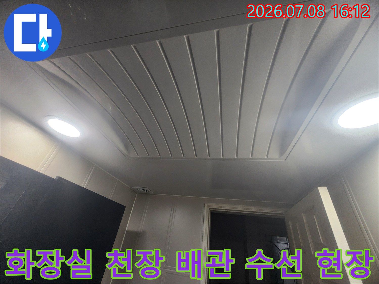 천장 마감재와 조명이 있는 공간 내 배관 작업 모습