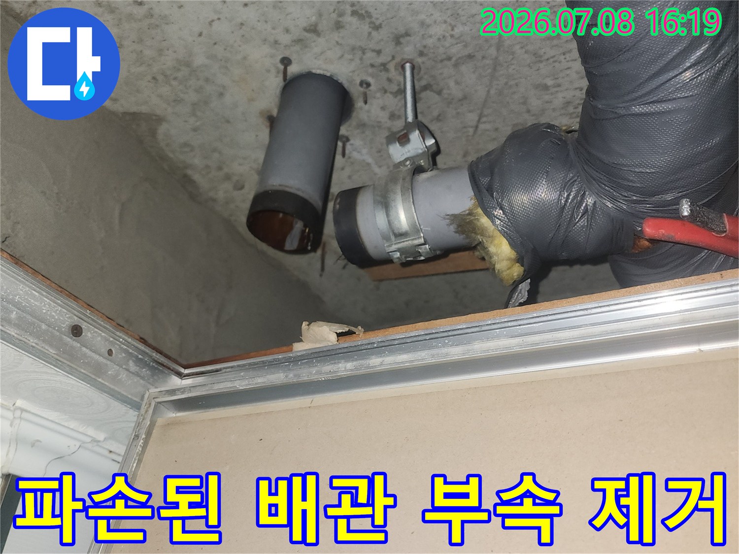화장실 천장 내부의 파손된 하수 배관 연결 부위를 교체하는 장면