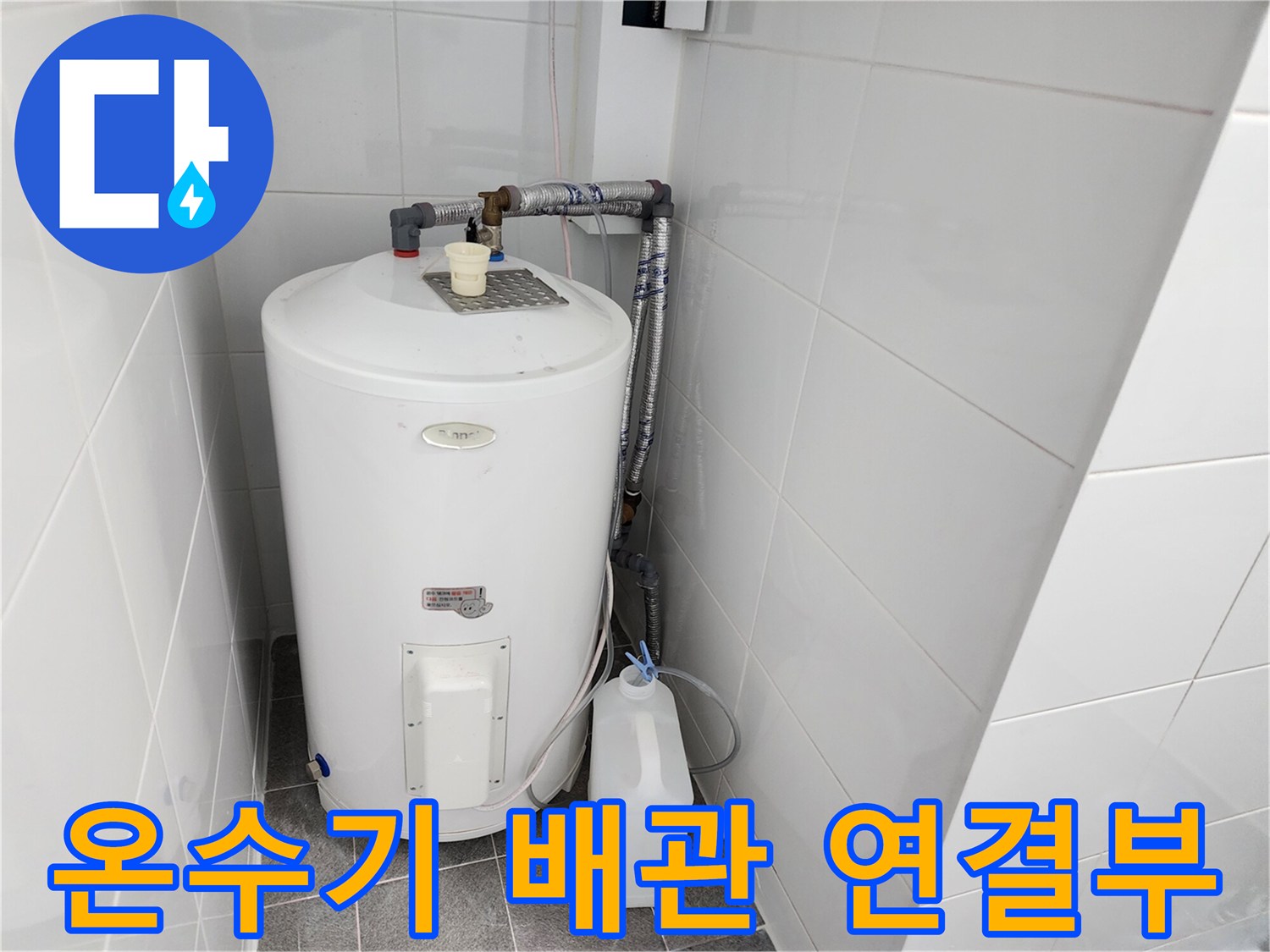 흰색 온수기와 벽면 타일 사이의 배관 연결 부위 상세 사진