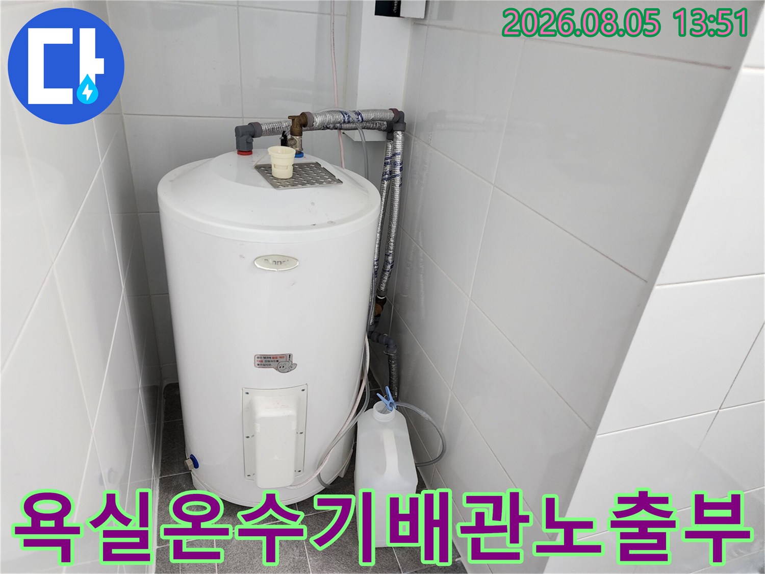 흰색 온수기와 은색 금속 배관이 연결된 실내 구조물