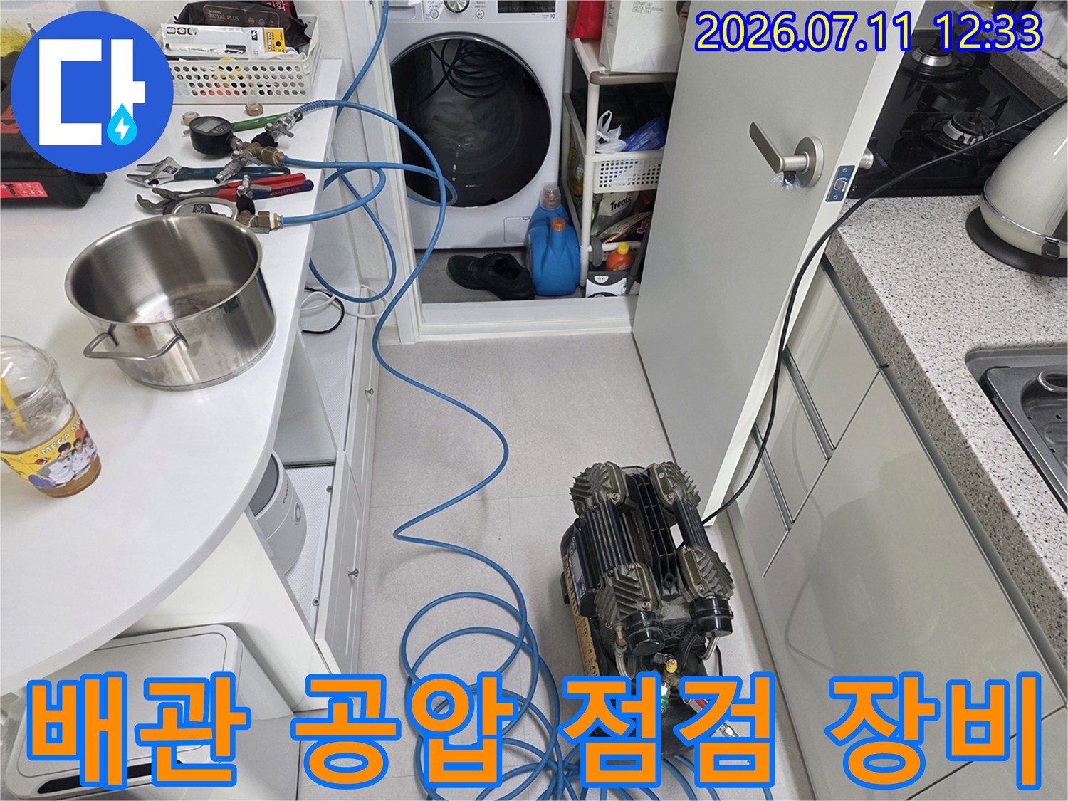 배관 내 압력을 측정하는 공압 시험 기계와 연결된 파란색 호스