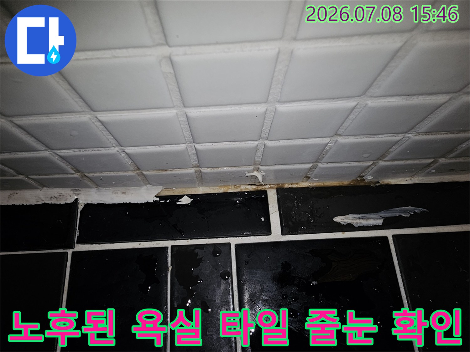 마모된 화장실 바닥 타일 메지 사이로 물이 스며드는 모습