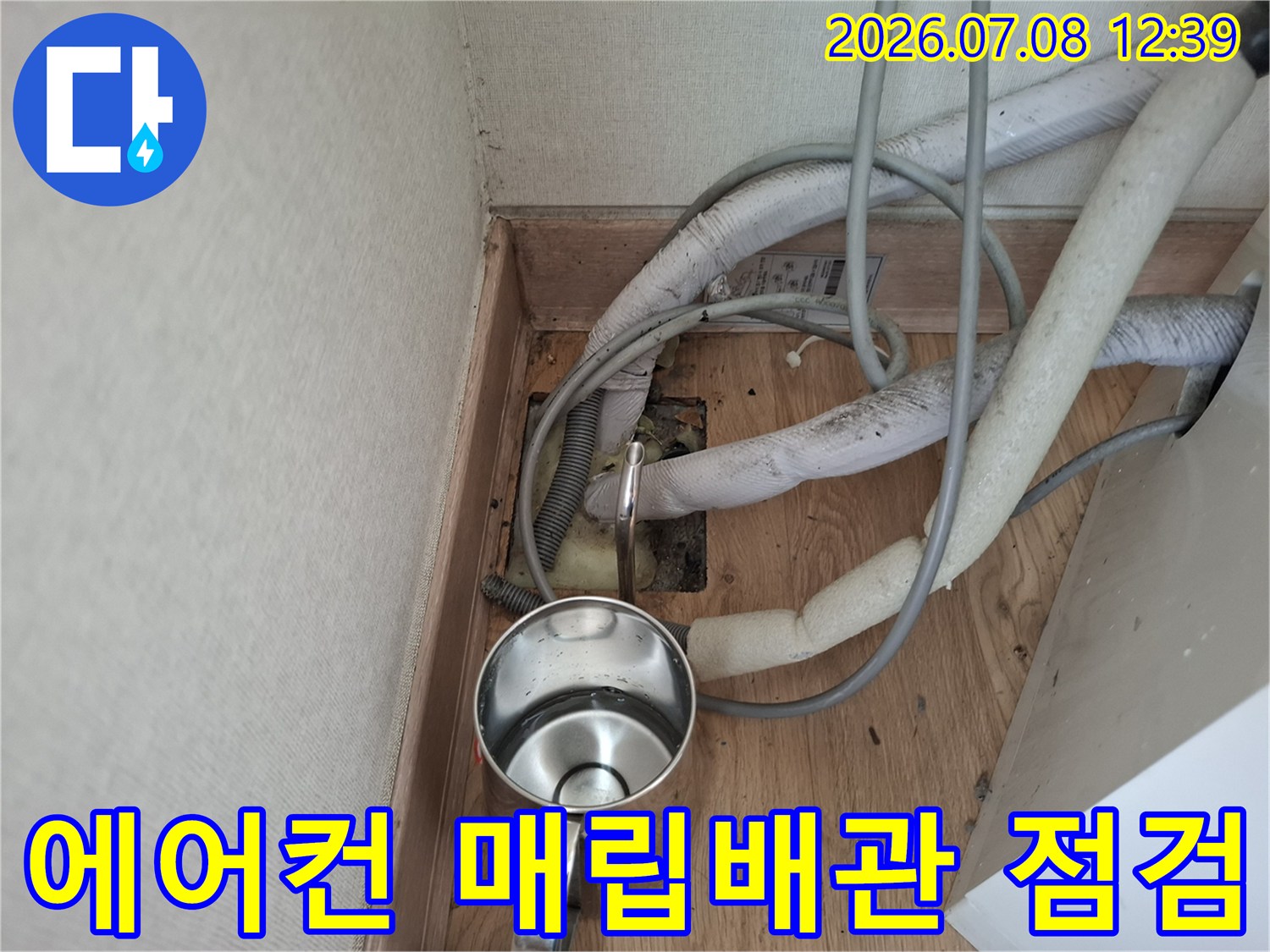 에어컨 배수용 매립배관의 연결 부위를 점검하는 모습