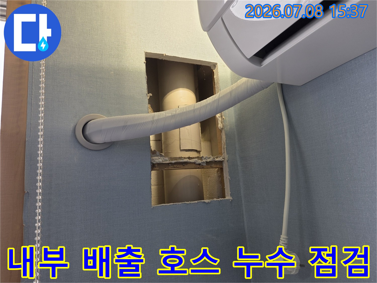 벽면을 절개하여 내부로 매립된 에어컨 드레인 배관 상태를 확인하는 장면