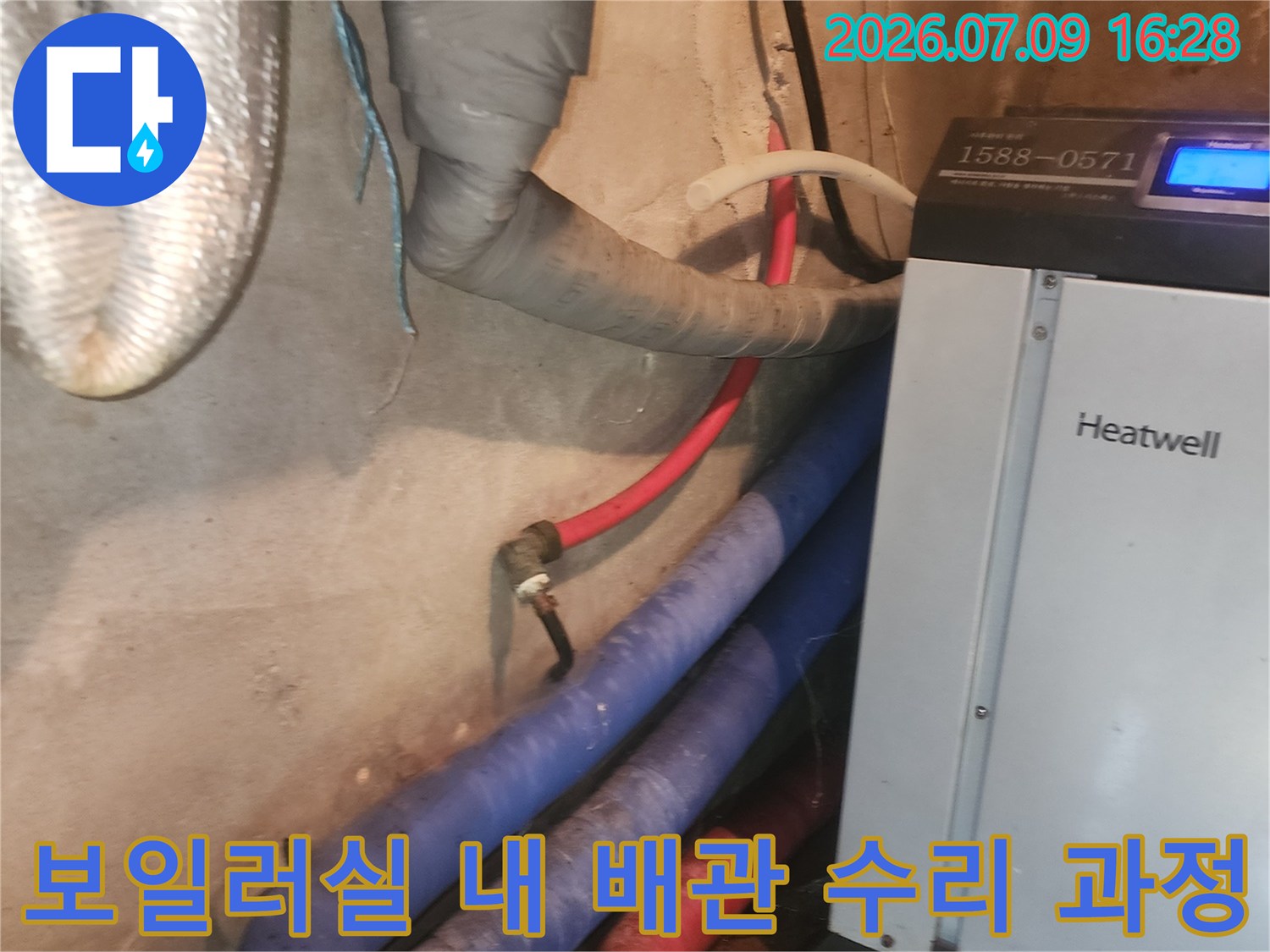 보일러 기계와 연결된 파란색 및 빨간색 배관과 보온재가 덮인 관