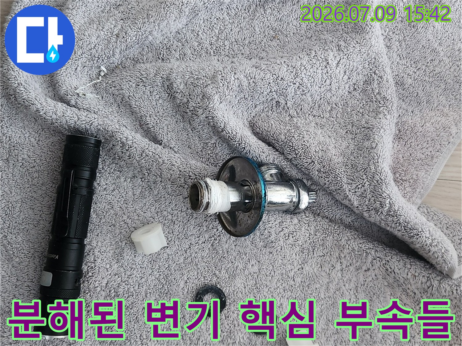 변기 내부를 구성하는 소모성 부속품과 앵글밸브를 분리하여 작업대에 놓아둔 모습