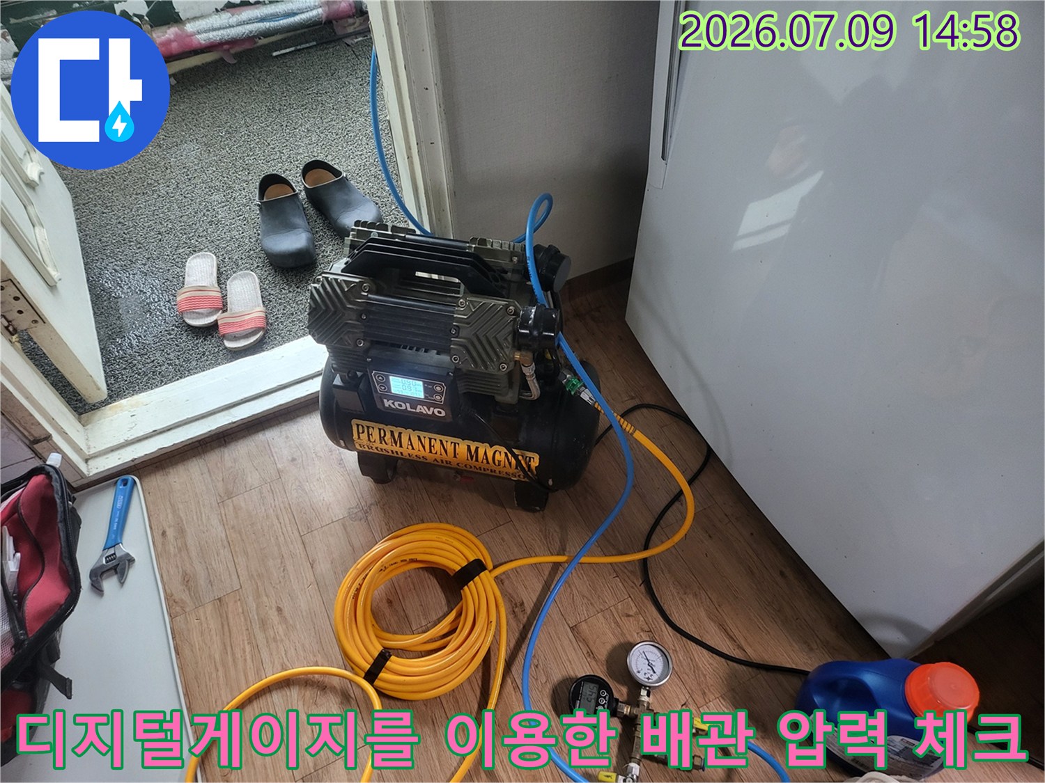 디지털 게이지와 가스 탐지기를 활용해 베란다 배관 누수를 점검하는 모습