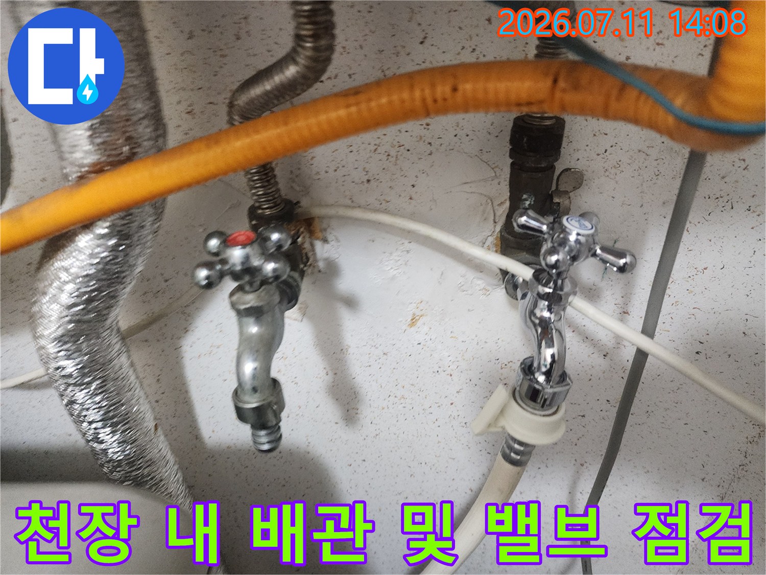 노출된 금속 제 배관과 주황색 단열재가 결합된 천장 내부 구조물