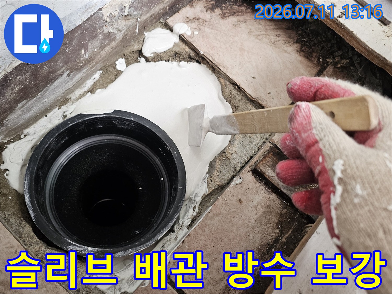 흰색 퍼티를 사용하여 하수 배관 주변의 틈새를 메우는 현장 모습