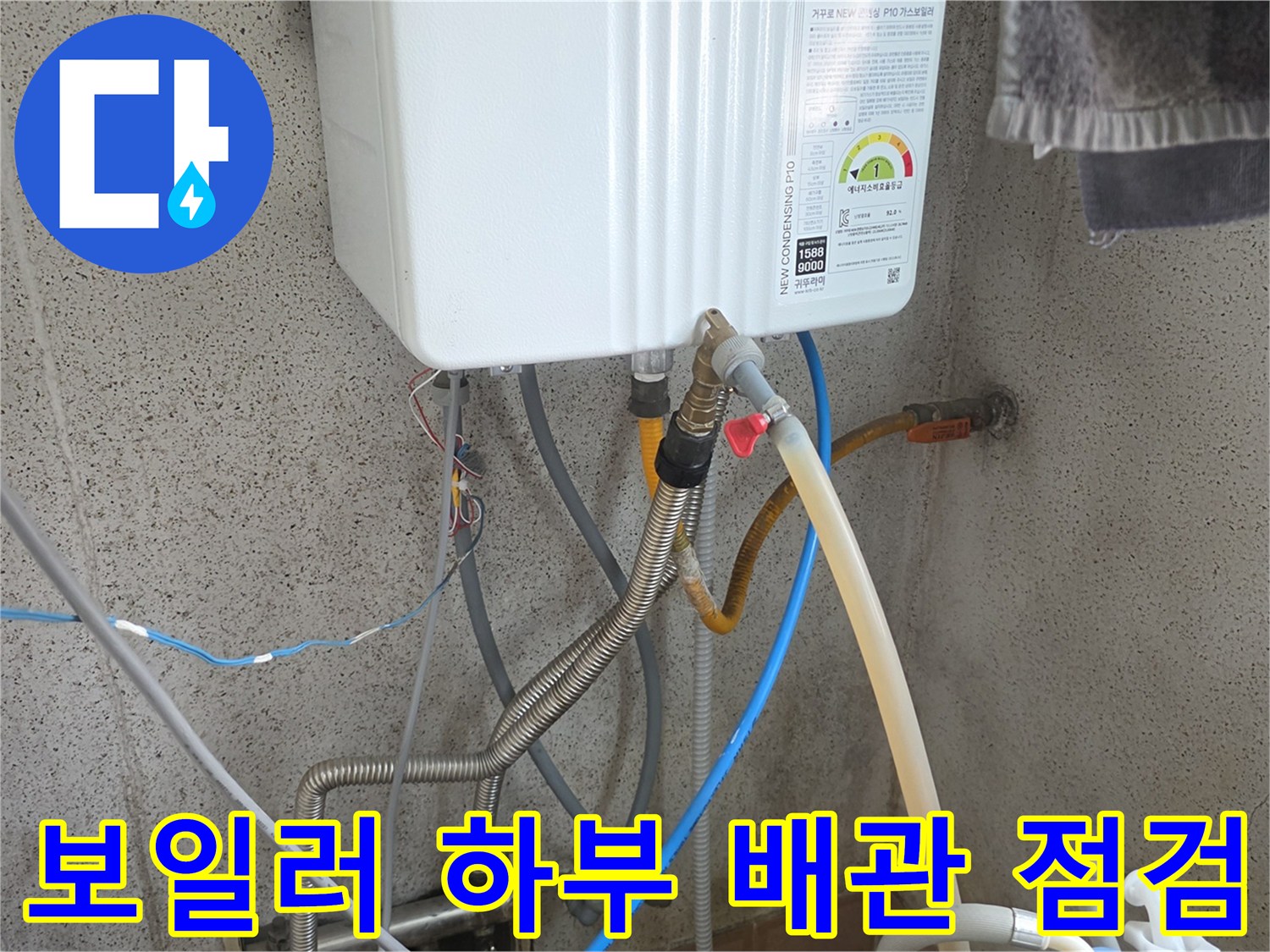 보일러 아래쪽의 다양한 배관과 호스들이 연결된 모습