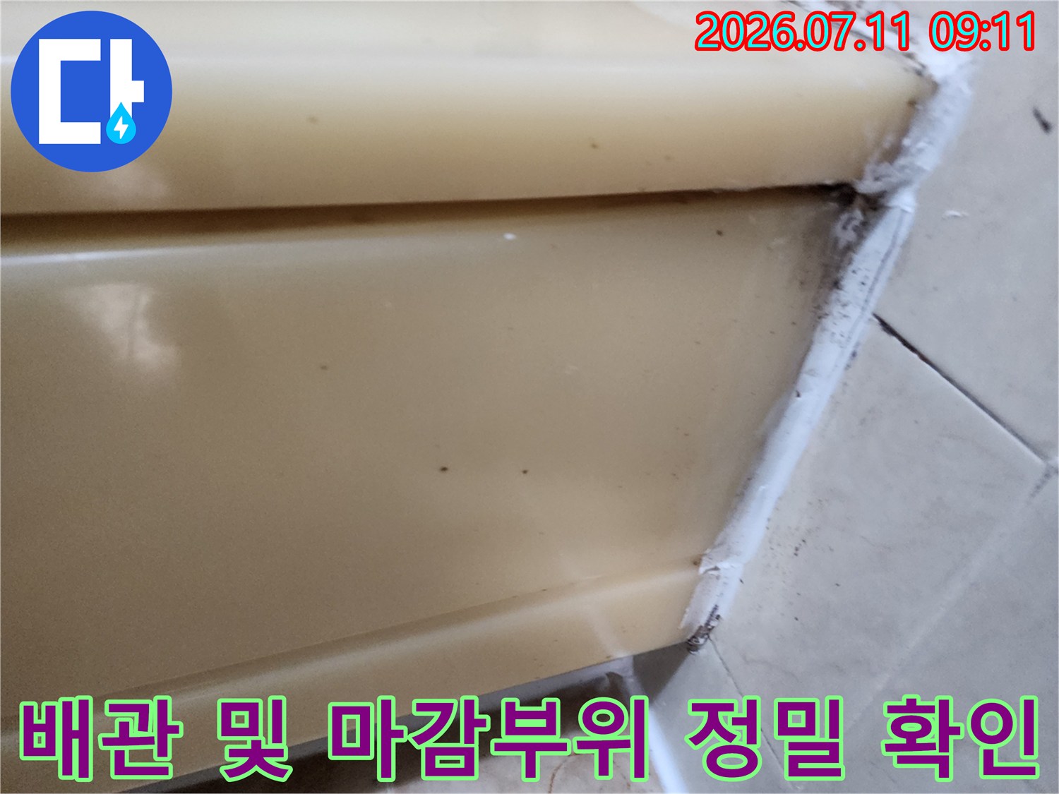 화장실 천장의 배관 통로와 주변 마감재 틈새를 면밀하게 점검하는 모습