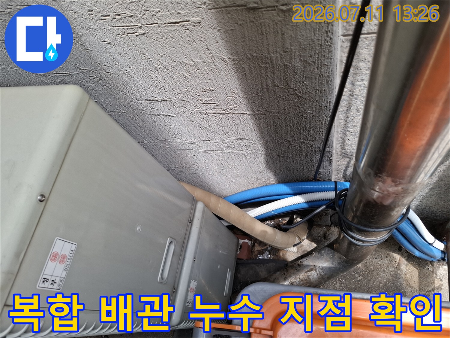 실외기 주변에 위치한 다수의 드레인 관을 상세히 분석하고 점검하는 모습