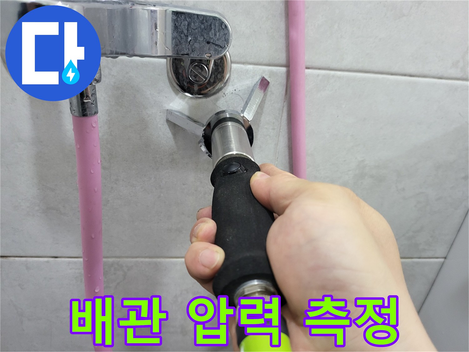 수도 배관의 누수 여부를 확인하기 위해 디지털 압력계를 연결한 장면입니다.