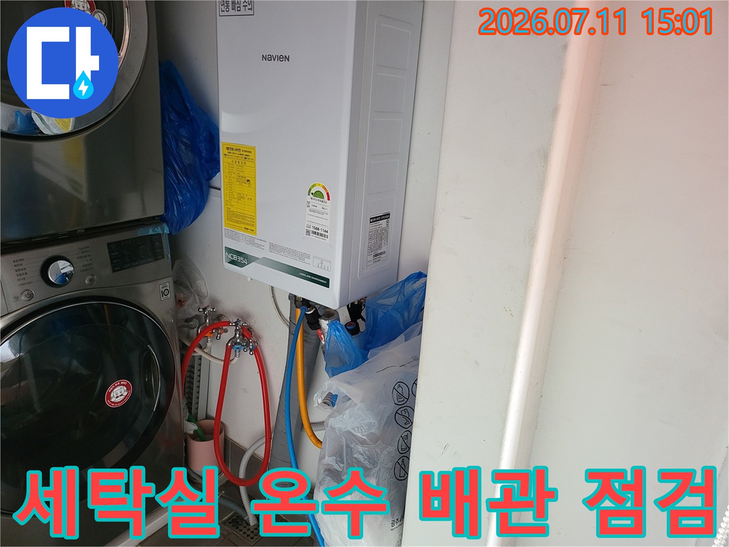 온수기 연결 부위의 배관 상태를 세밀하게 검사하는 장면