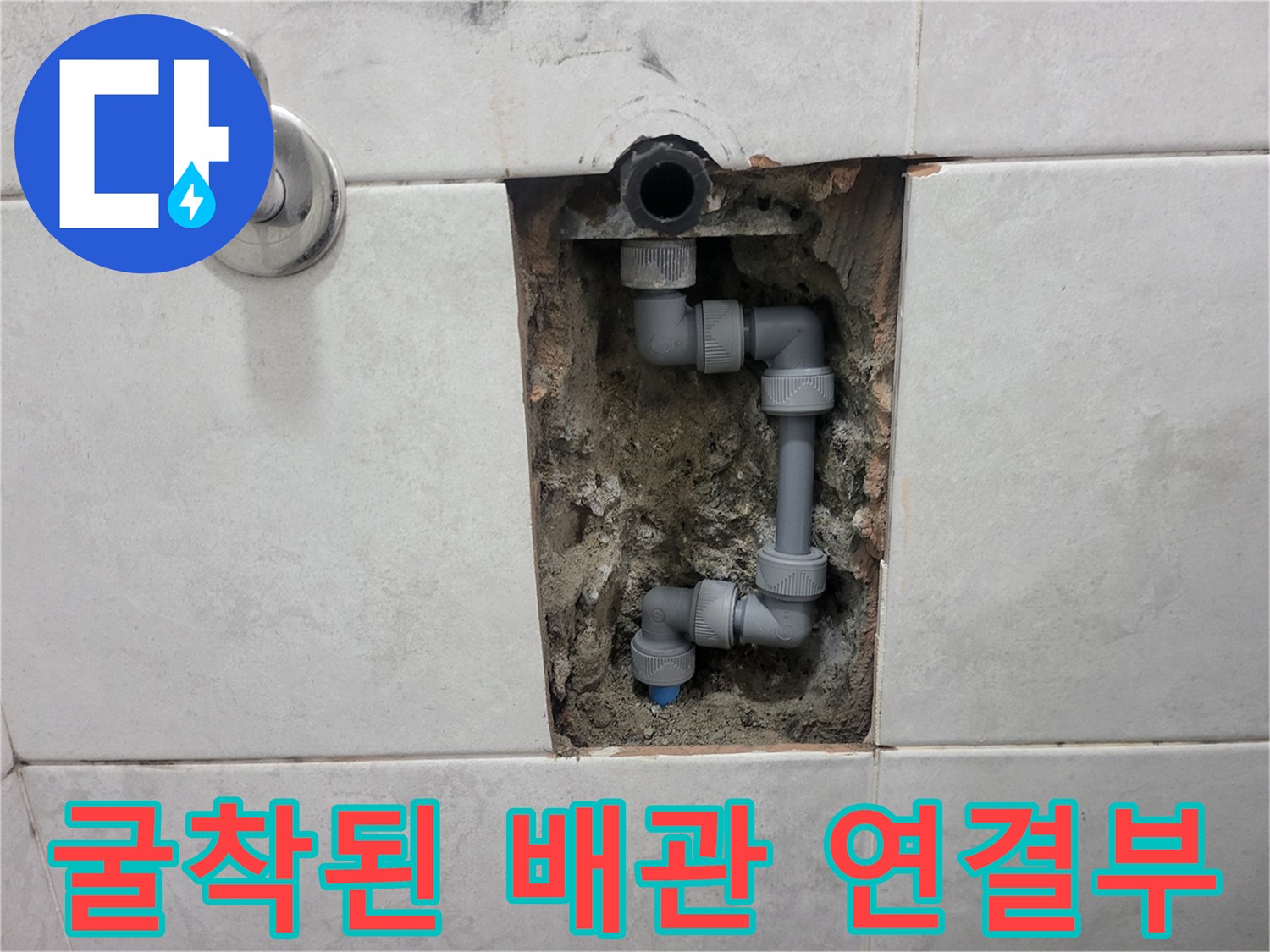 타일 틈새로 보이는-수도 배관과 엘보 교체 작업 부위