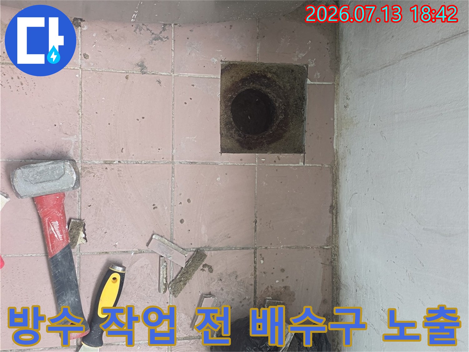 노후된 세탁실 배수관 입구를 정리하고 보강 공사를 준비하는 장면