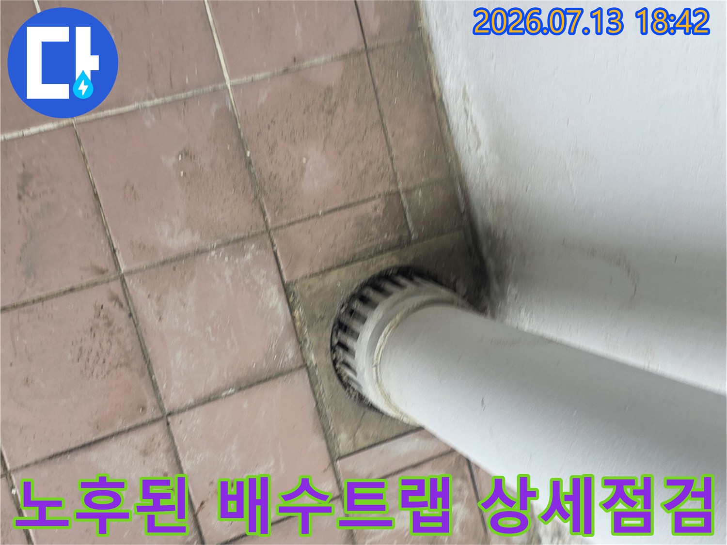 세탁기용 배수 트럼과 바닥 타일의 접합부 상태를 근접 촬영한 사진