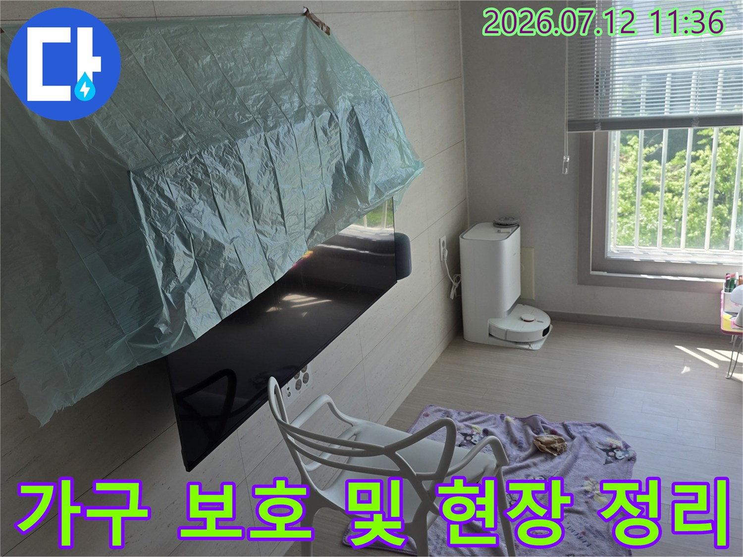 책상에 덮인 비닐과 공기청정기가 위치한 실내 공간