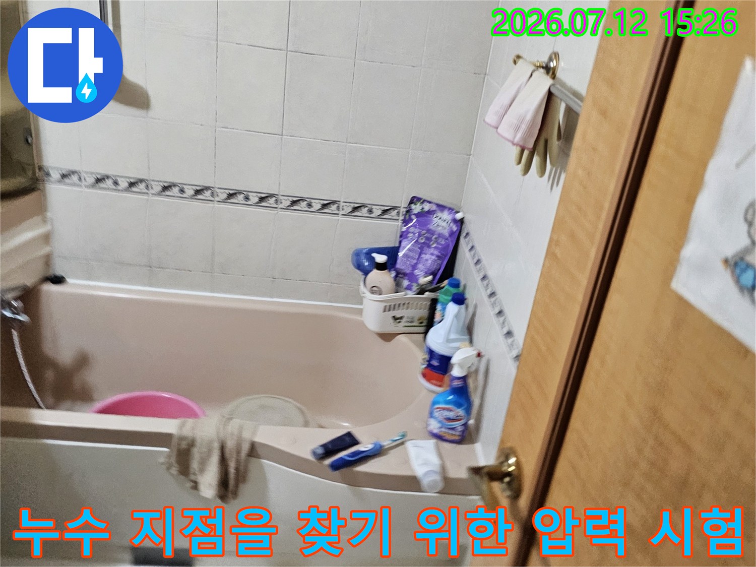 화장실 배관에 장비를 연결하여 기밀 상태를 점검하는 현장 사진