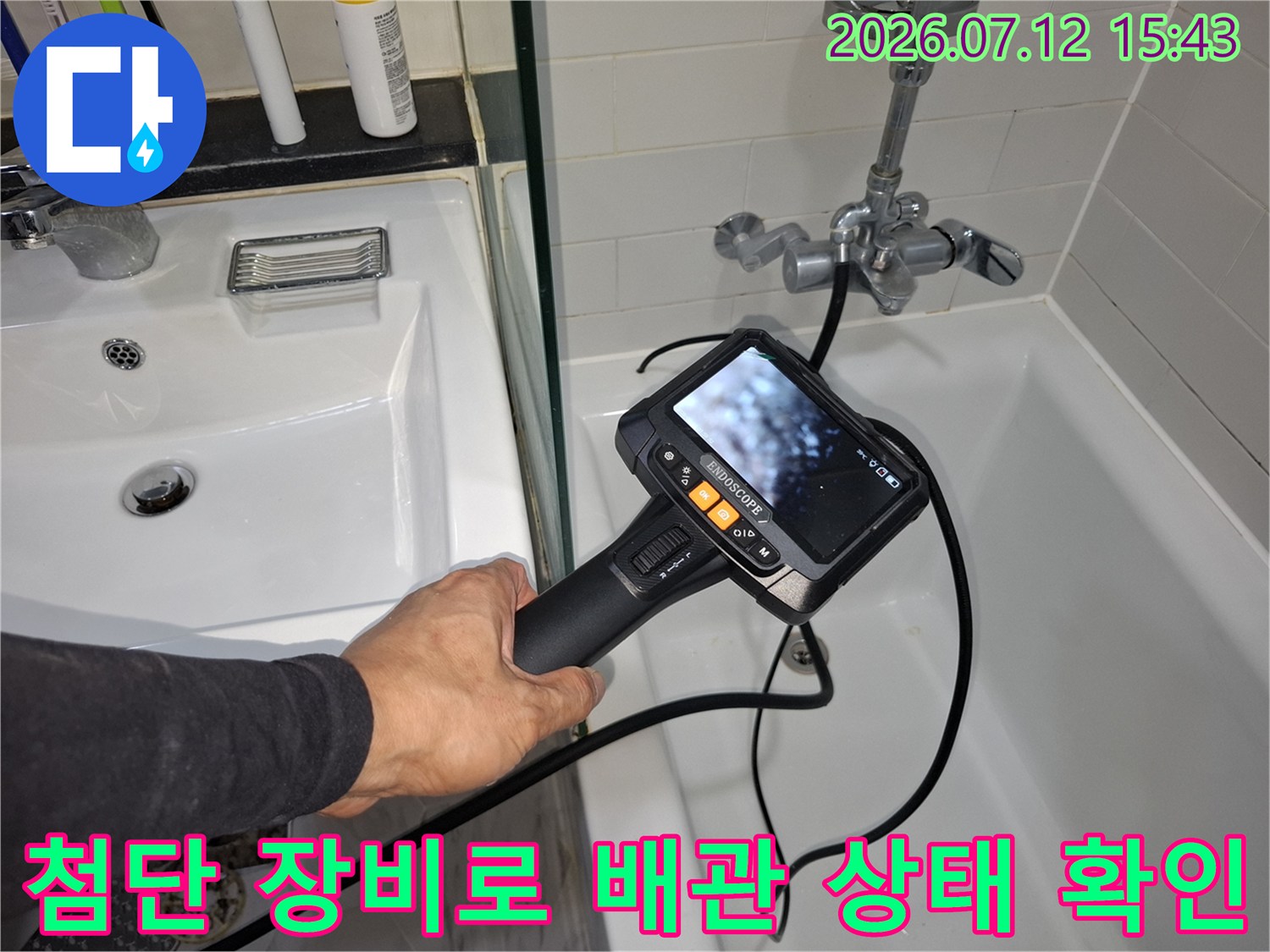 화장실 내 위치한 배관의 이상 유무를 디지털 기기로 정밀 측정하는 장면