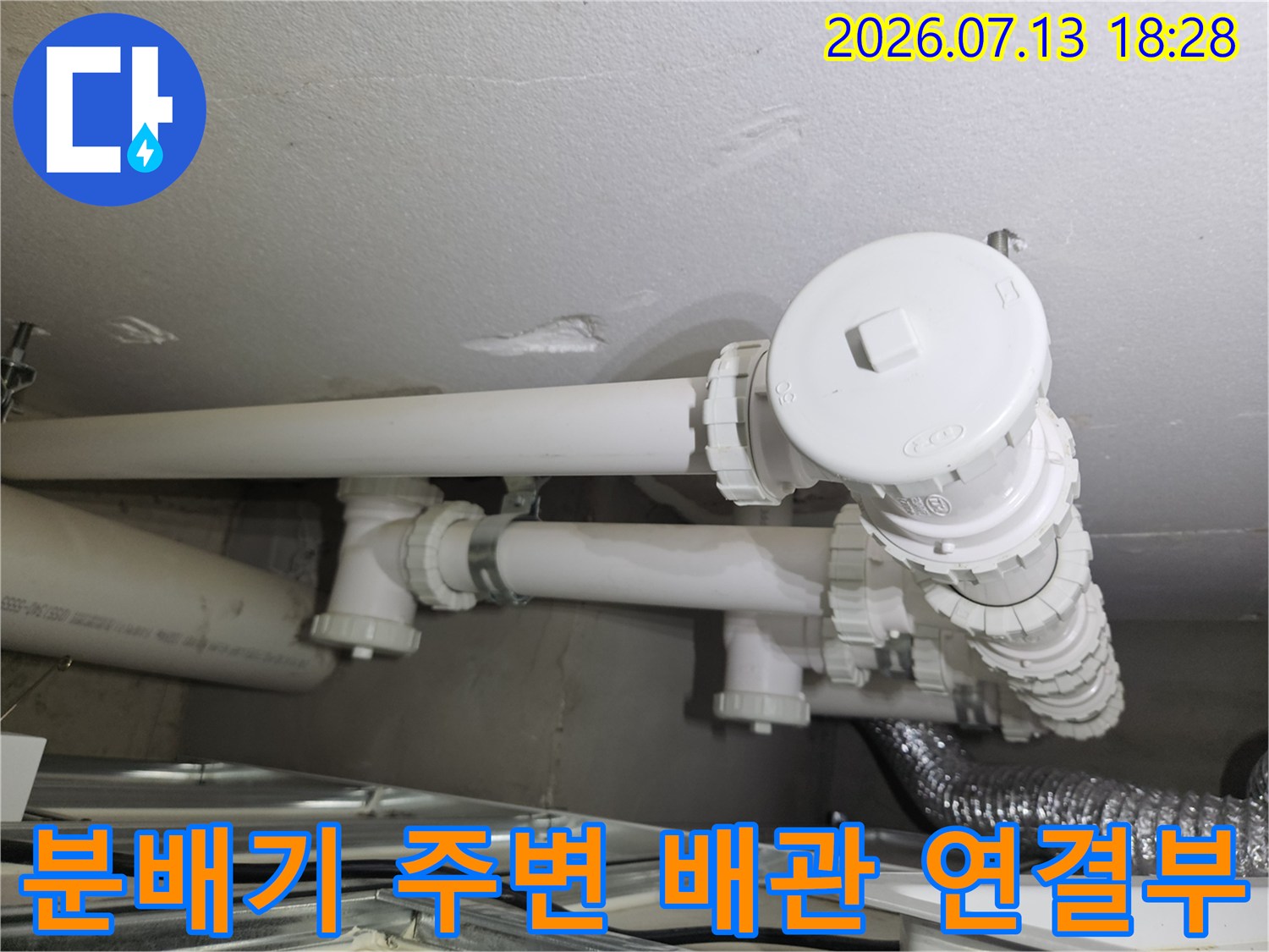 하얀색 분배기와 노출된 세탁실 바닥 배관 시스템의 모습