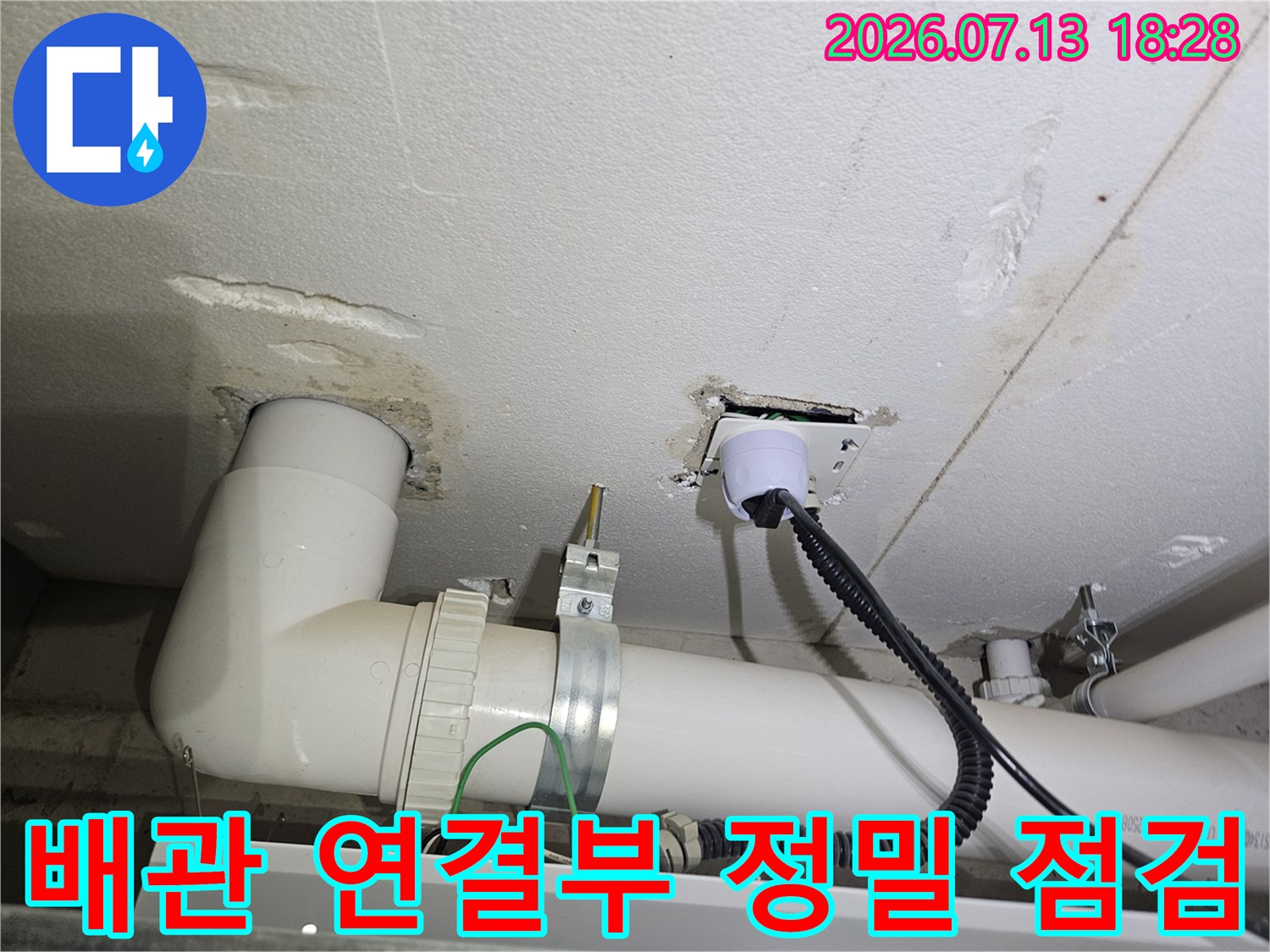 흰색 배관과 바닥면 경계 부위의 누수 가능성을 조사하는 모습