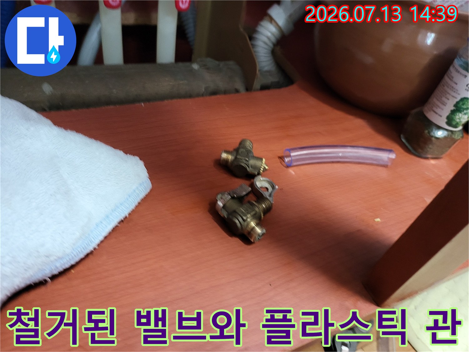 누수 원인으로 판명되어-제거한 금속 밸브들과 보라색 투명 호스