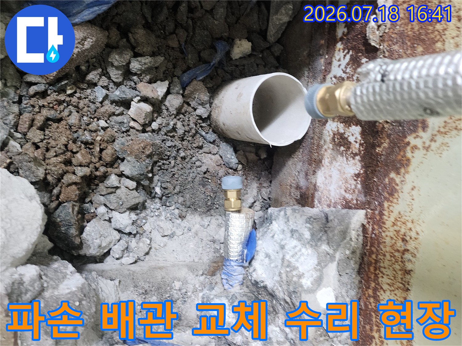부식된 노출 배관과 굴착된 바닥의 보수 작업 모습