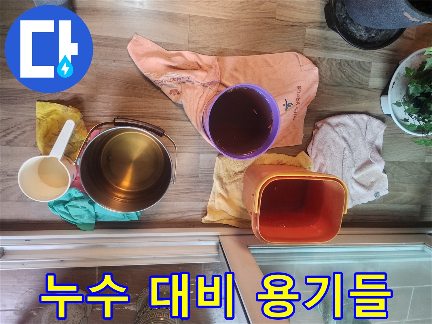 바닥에 놓인 붉은색과 투명한 물받이 통들