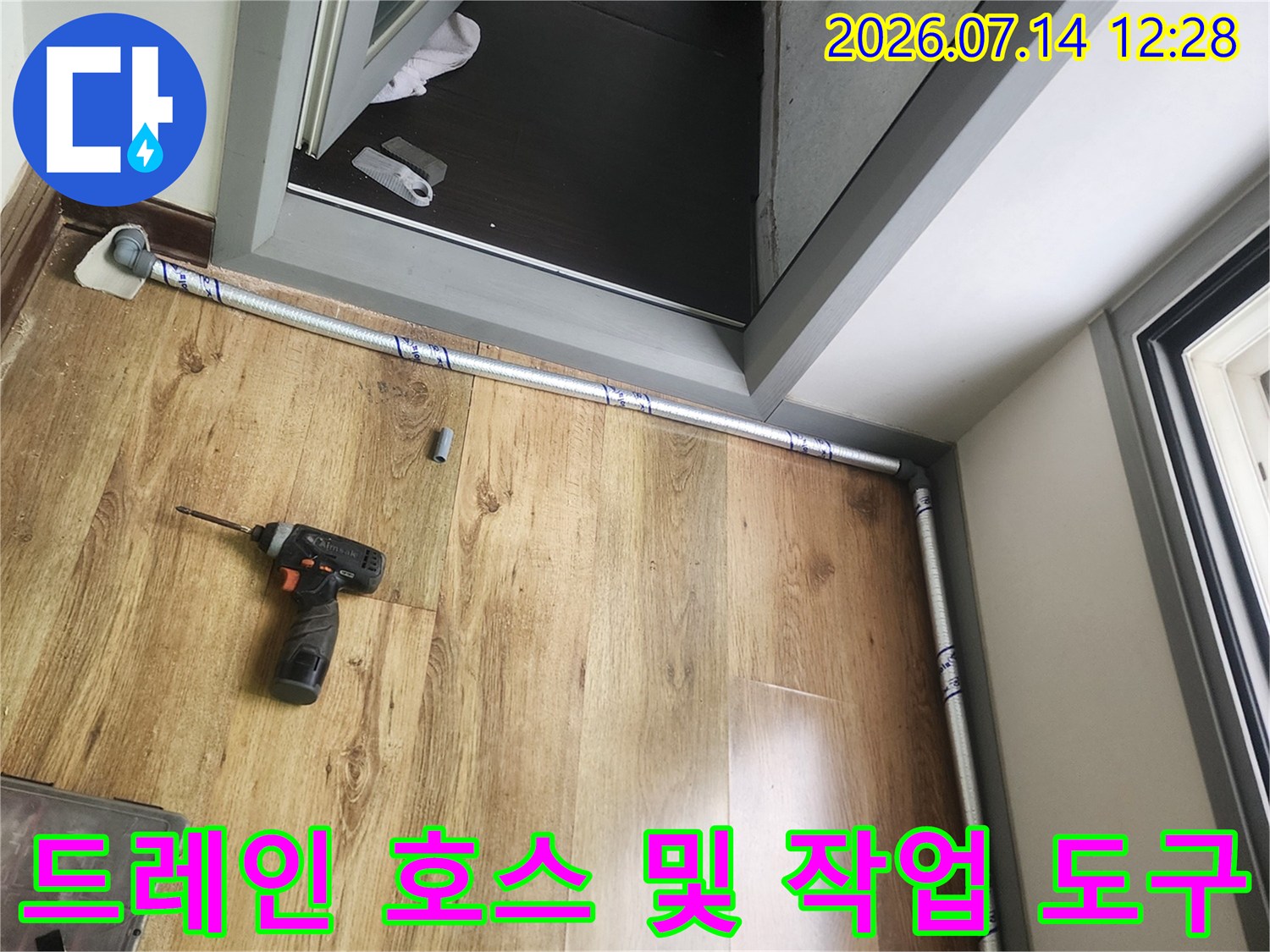 작업 중인 베란다 바닥의 배관과 전기드릴 장비 모습
