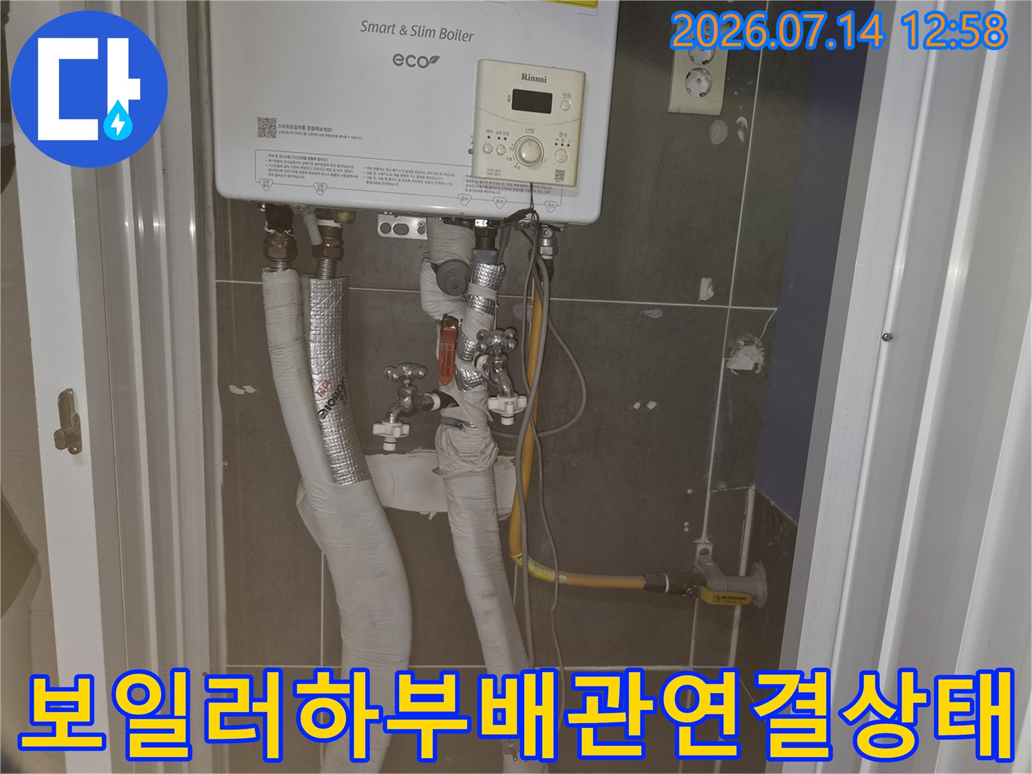 린나이 보일러 본체 아래로 늘어진 수도 및 가스 배관들의 상세 모습