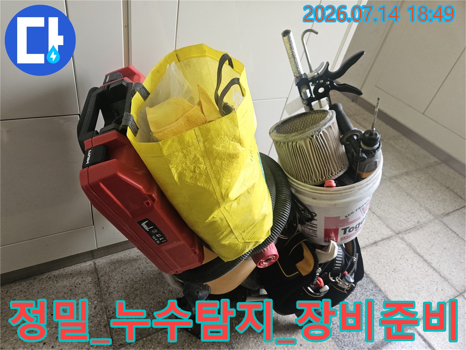 배관 보수를 위한 전동 공구와 수전 관련 부품이 담긴 양동이