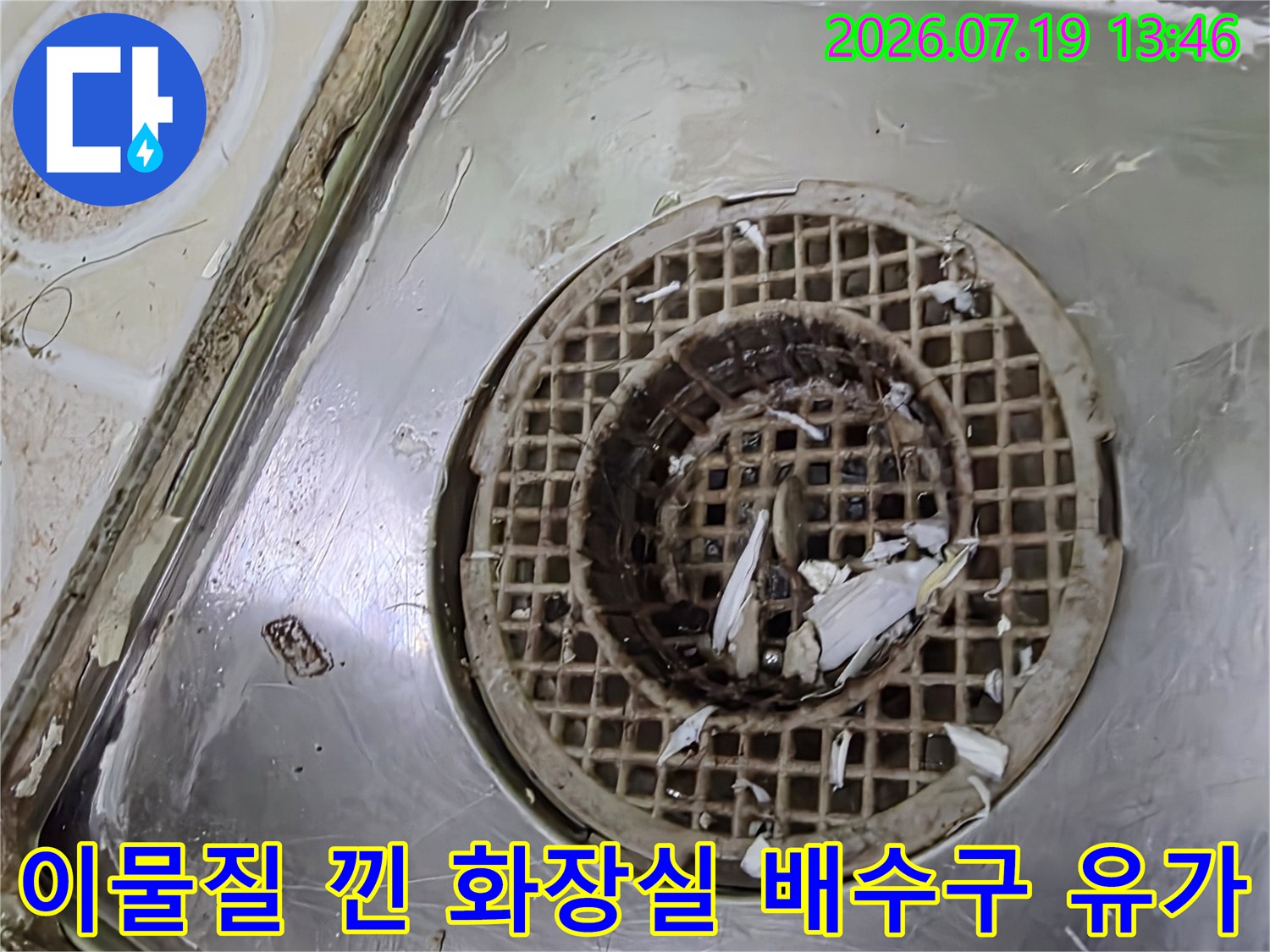 화장실 바닥의 스테인리스 재질-배수구 유가 속에 이물질이 쌓여있는 모습