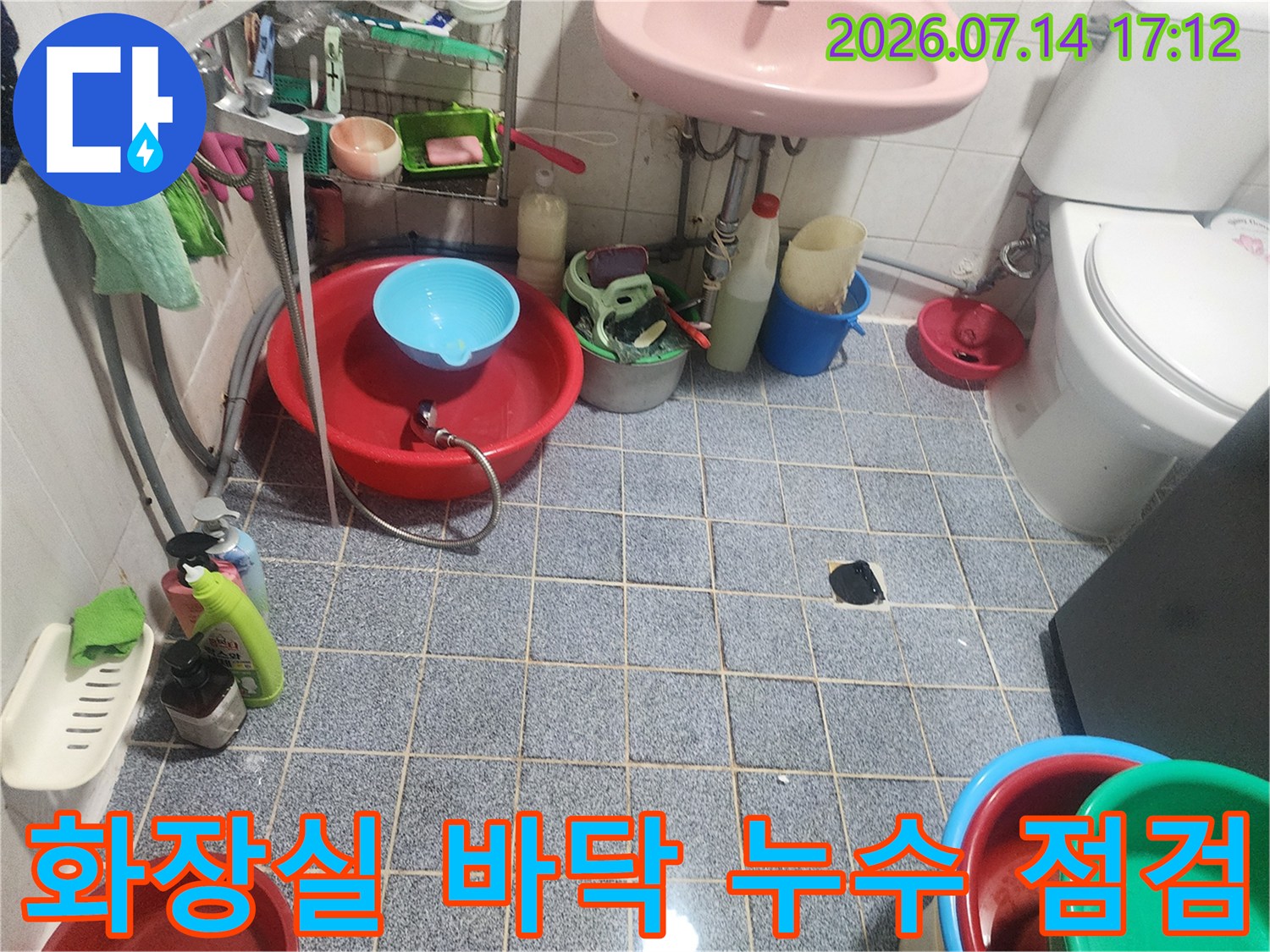 욕실 바닥 타일과 배수구 주변을 정밀하게 점검하는 현장 모습